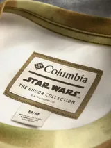 Remera de manga corta con estampado de camuflaje en tonos verdes y marrones, con logo de la Alianza Rebelde en el pecho y logo de Columbia en la manga. Cuenta con tecnología de protección solar.