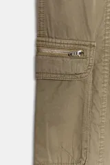 Pantalón cargo de tiro medio en color verde militar, con cierre frontal de cremallera y botones metálicos. Presenta bolsillos laterales, bolsillos de plastrón en las piernas con cierre de cremallera y trabillas en la cintura.