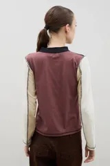 Remera de cuello alto y manga larga en color crudo, con costuras a la vista en contraste de color marrón.