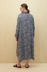 Vestido midi con estampado paisley en tonos azules y beige, con cuello camisero y abotonadura frontal.