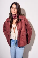 Sobrecamisa color borgoña de gamuza sintética con cuello camisero, cierre frontal con botones a tono, bolsillos de parche con solapa en el pecho y mangas largas con puños abotonados.