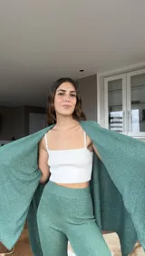 Pantalón largo de tejido de punto color verde esmeralda con lurex, corte ajustado y acampanado.