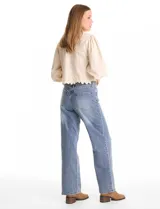 Blusa color beige con bordado floral al tono en el pecho y la espalda. Presenta mangas largas abullonadas con frunces en los hombros y puños festoneados. El ruedo cuenta con un acabado festoneado en ondas y la espalda incluye una abertura tipo gota con cierre de botón.