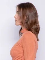 Polera color salmón de textura acanalada, cuello alto y mangas largas con ajuste fruncido en los laterales.