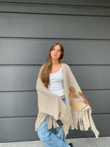 Chal beige con flecos y apliques marrones.