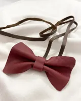 Gargantilla tipo choker con dije de moño de cuero color borgoña y tiento de cuero marrón.