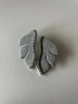 Aro dorado con forma de hoja y detalle de strass.