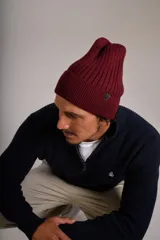 Gorro de lana tejido en punto rib, color bordó, con diseño de doblez en el borde y etiqueta pequeña lateral.