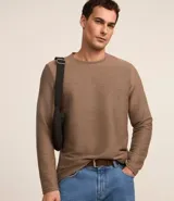 Remera de manga larga con cuello redondo y textura acanalada en tejido de punto. Diseño liso sin estampas.