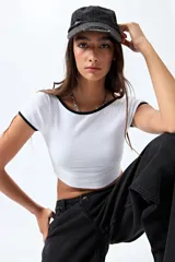 Top blanco de punto acanalado, corte crop y silueta ajustada, con cuello redondo y mangas cortas con ribete negro.