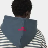 Hoodie de algodón con cierre frontal completo, diseño a rayas horizontales blancas y grises, capucha azul marino, y bordado "EMESTUDIOS Always Grateful" en el pecho en color rojo. Cuenta con bolsillos delanteros tipo canguro, puños y bajo de canalé, y un pequeño logo bordado en la parte posterior de la capucha.