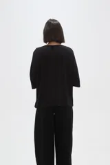 Remera de viscosa en color verde oliva, con cuello redondo y mangas 3/4. Presenta un diseño de tejido acanalado y corte holgado.