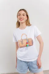 Remera blanca de algodón con estampado de un bolso con llavero colorido.