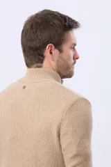 Cardigan de punto grueso color azul marino, con cuello alto, cierre frontal de botones y ribetes en contraste color marrón.