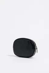 Monedero ovalado color blanco de la marca Bimba y Lola, confeccionado en piel. Cuenta con cierre de cremallera, tirador metálico, logo estampado y ribetes metálicos.