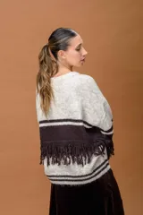 Sweater de punto con diseño de bloques de color en tonos beige y marrón, con detalle de flecos en el pecho y las mangas, cuello redondo y corte holgado.