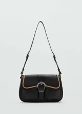 Bolso de hombro de cuero bovino en color negro con detalles en contraste color beige. Presenta un diseño con bolsillos tipo cargo en el frente, cierre de solapa con hebilla decorativa y cierre principal de cremallera. Incluye asa ajustable.