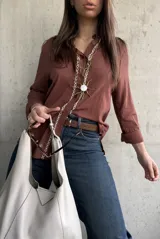 Camisa de tejido liviano y calce relajado, color marrón chocolate, con cuello mao, mangas largas y detalle de puntilla y bordado en contraste a lo largo de la botonadura frontal.