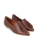 Mocasines de cuero color marrón, con diseño de punta fina, detalle de borlas en el empeine y taco bajo con aplique metálico dorado mate.