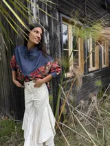 Camisa oversize combinada que mezcla denim azul en la parte superior y mangas, con tela vintage de estampado geométrico y tribal multicolor en la espalda y mangas. Presenta cuello camisero y corte holgado.