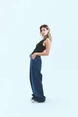 Jean de corte oversize confeccionado en denim de algodón con lavado azul clásico. Presenta tiro medio-bajo, cierre frontal con botón y bolsillos laterales.