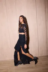 Top negro de manga larga, corte cropped y cuello alto, confeccionado en encaje con patrón geométrico. El cuello tiene un detalle de pedrería o brillo.