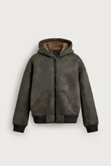 Cazadora relaxed fit de tejido efecto piel en color gris oscuro con efecto lavado, interior de borreguillo en tono tostado, capucha, bolsillos de vivo en la cadera, acabados en rib y cierre frontal de cremallera.