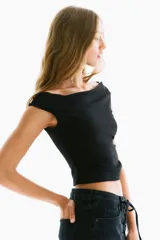 Top negro de punto, ajustado al cuerpo, con escote barco drapeado y frunces laterales.