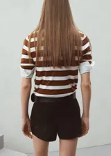 Chaleco de punto a rayas horizontales en tonos marrón y blanco, con cuello polo y diseño sin mangas.