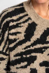 Sweater de lana color beige con estampado animal print en negro.