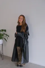 Conjunto de dos piezas compuesto por un buzo de cuello redondo y mangas largas con diseño holgado y un pantalón de corte recto y tiro alto. Ambas prendas están confeccionadas en tejido de punto acanalado.