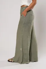 Pantalón verde oliva de lino, corte palazzo, con cintura elástica y aberturas laterales con botones.
