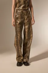Pantalon de corte recto con diseño de estampado de piel de serpiente, confeccionado en cuero sintético (PU). Presenta bolsillos laterales y cierre frontal con botón.