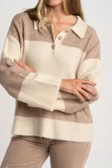 Sweater de punto con cuello polo y cierre frontal de tres botones. Presenta un diseño de corte oversize, mangas largas y textura acanalada.