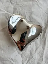 Pinza de pelo plateada con forma de corazón. Fabricada en aleación metálica.