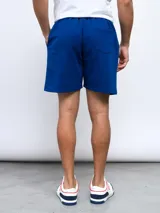 Bermuda de felpa color celeste, con cintura elástica y cordón de ajuste. Presenta el logo Umbro bordado en la pierna izquierda.