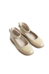 Chatitas de cuero charolado color beige, con diseño de punta redondeada y tira desmontable en el tobillo con cierre de velcro.
