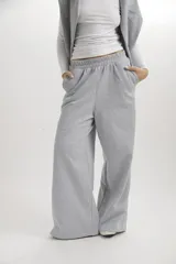 Pantalón de felpa gris melange, de corte holgado y pernera ancha, con cintura elástica fruncida y bolsillos laterales.