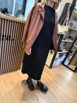 Vestido midi color beige de tejido acanalado, con cuello alto y mangas largas.