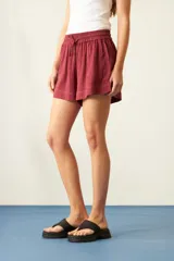 Short color borgoña de viscosa con cintura elástica ajustable con cordón, bolsillos laterales y corte holgado.