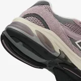 Championes urbanos New Balance modelo 2010, color rosado con detalles en gris y blanco. Confeccionados en una combinación de gamuza y malla, presentan el logo N característico en los laterales y una entresuela con tecnología de amortiguación visible en el talón.