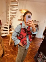 Chaleco color crema con ribete amarillo, de corte recto y sin mangas.