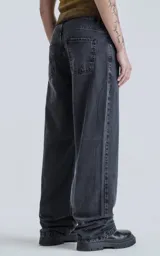 Pantalón de denim negro lavado, estilo wide leg, de cinco bolsillos y tiro alto.