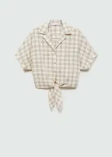 Blusa de algodón con diseño de cuadros, cuello camisero, manga corta y cierre frontal con botones. Presenta un diseño corto con detalle de lazo para anudar en la cintura.