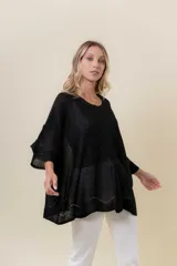 Buzo de tejido liviano con brillo sutil tipo lurex, color beige o dorado claro. Presenta un calce suelto (oversize) con mangas amplias y cuello redondo. El ruedo tiene un detalle de terminación festoneado con pequeños calados.