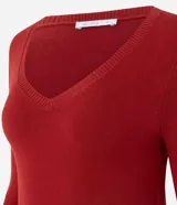 Blusa básica de punto fino color rojo, con escote en V y mangas largas. Presenta terminaciones acanaladas en el cuello, puños y ruedo.
