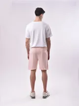 Bermuda de algodón color crudo, de corte recto y largo a la rodilla, con cintura elástica y cordón ajustable negro.