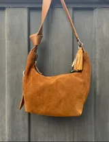 Cartera bandolera marrón de gamuza con correa ajustable de cuero.