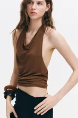 Top halter marrón de punto elástico con escote drapeado, tiras anchas para atar al cuello y ajuste en la parte posterior del bajo.
