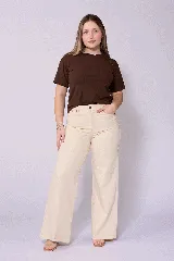 Jean de corte wide leg en color beige, con tiro alto y cierre frontal con botón y cremallera. Presenta un diseño de cinco bolsillos y costuras reforzadas.